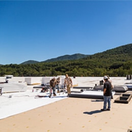 workmen working on commercial roof replacement